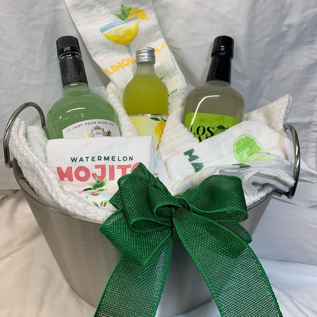 A cocktail gift bucket with mixers, liquor, and bar towels