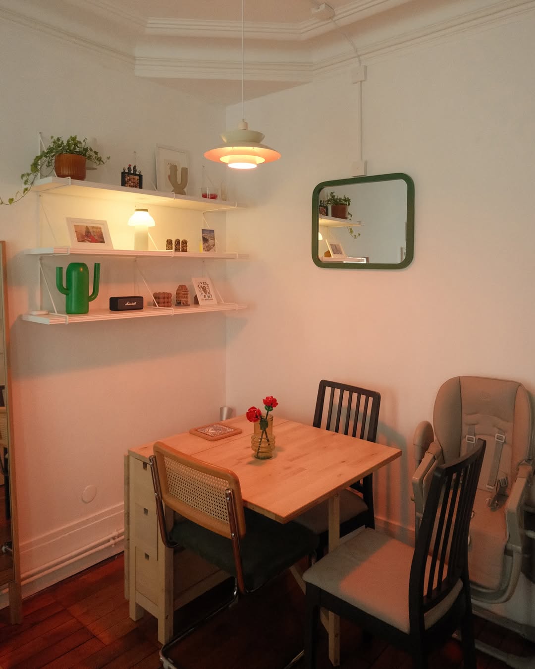 Apartment dining area with layered lights and vertical shelves